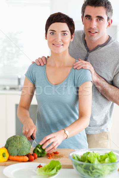 Husband massaging his wife while she's cutting vegetables in a kitchen Stock photo © wavebreak_media