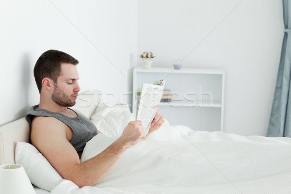 Człowiek czytania gazety sypialni świetle Zdjęcia stock © wavebreak_media
