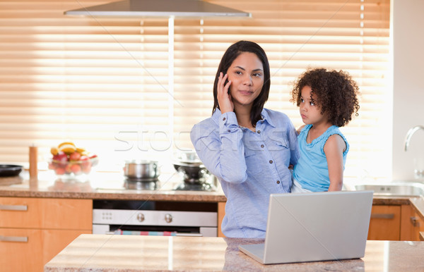 Genç anne kız cep telefonu dizüstü bilgisayar mutfak Stok fotoğraf © wavebreak_media