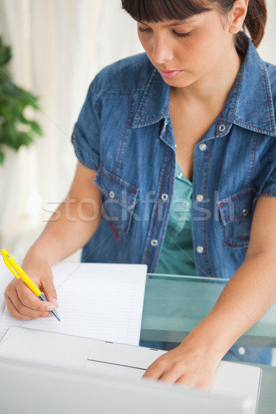 Unsmiling student doing her homework with her laptop Stock photo © wavebreak_media