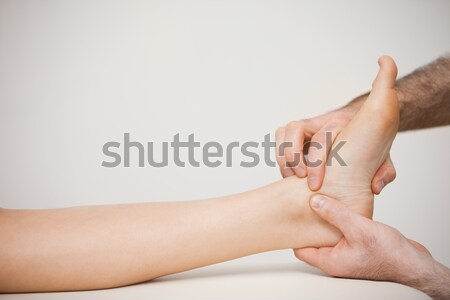 Stock photo: Doctor placing his fingers on the foot of a patient in a room