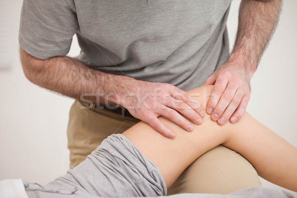 Physiotherapist massaging the knee of a woman in a room Stock photo © wavebreak_media