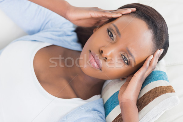 Black woman lying while putting hands on temples in a living room Stock photo © wavebreak_media
