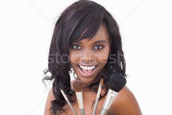 Smiling woman with four makeup brushes Stock photo © wavebreak_media