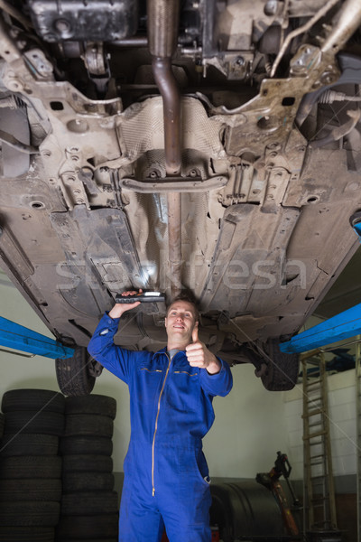 Male mechanic under car gesturing thumbs up Stock photo © wavebreak_media