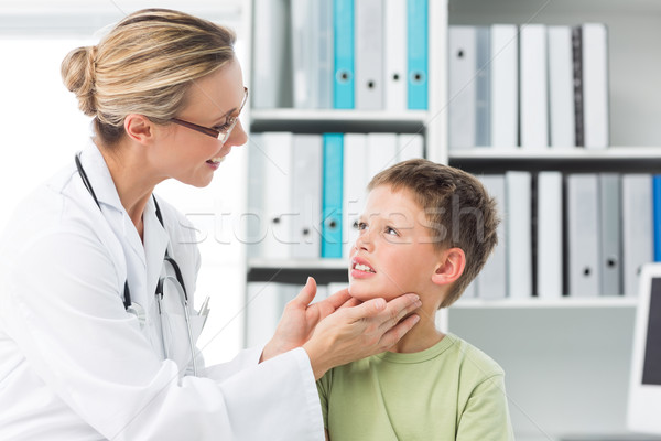 Pediatrician examining thyroid gland of boy Stock photo © wavebreak_media