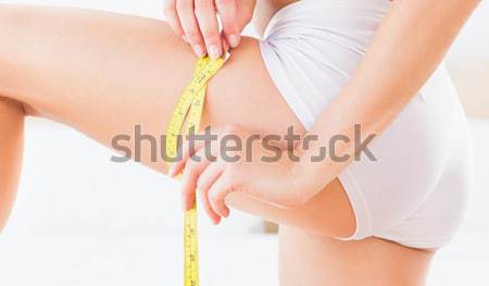 Slim woman measuring her thigh Stock photo © wavebreak_media