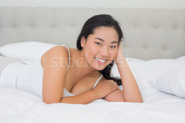 улыбаясь азиатских женщину кровать домой спальня Сток-фото © wavebreak_media