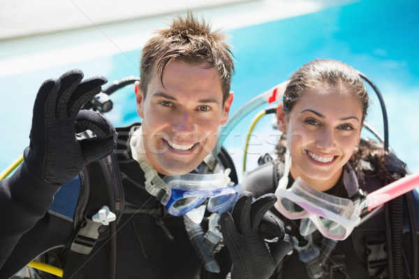 Smiling couple on scuba training in swimming pool showing ok ges Stock photo © wavebreak_media