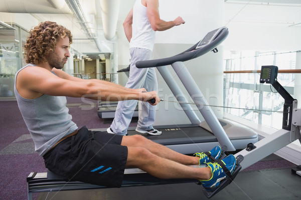 S'adapter jeune homme fitness machine gymnase vue de côté [[stock_photo]] © wavebreak_media