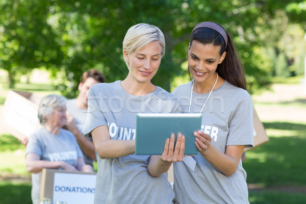 Happy volunteer friends using tablet pc  Stock photo © wavebreak_media