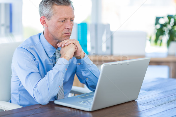 Concentrated businessman looking at laptop computer  Stock photo © wavebreak_media