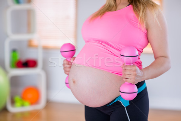 A pregnant woman holding dumbbells  Stock photo © wavebreak_media