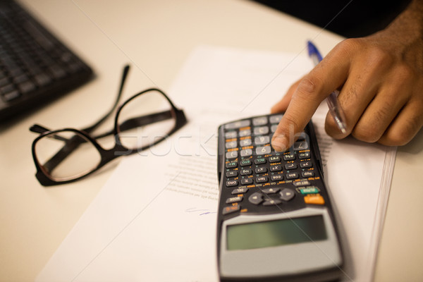 Cropped hand on business person using calculator by eyeglasses at office Stock photo © wavebreak_media