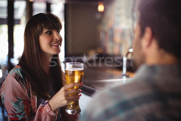 Happy couple interacting while having beer at counter Stock photo © wavebreak_media