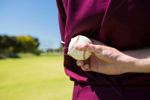 Mid section of baseball player holding ball behind back Stock photo © wavebreak_media