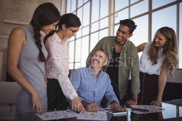 Smiling businessman discussing with young team on desk Stock photo © wavebreak_media