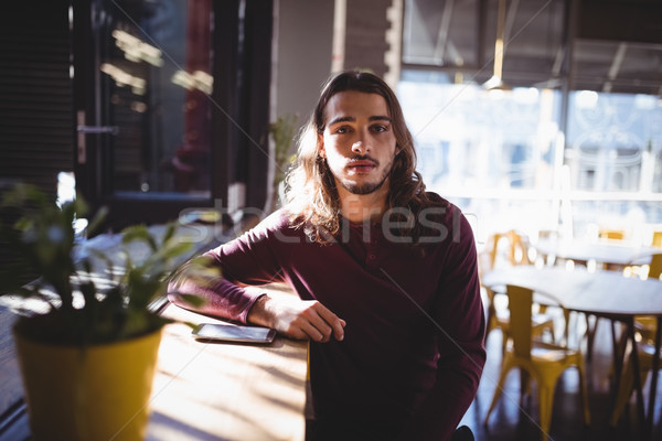 Portrait of young man with long hair sitting at coffee shop Stock photo © wavebreak_media