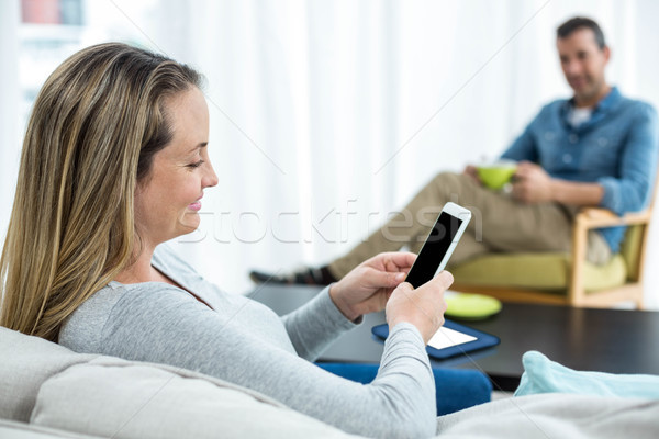 Femeie gravida smartphone şedinţei canapea femeie casă Imagine de stoc © wavebreak_media