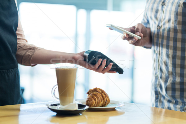 Man paying bill through smartphone using NFC technology Stock photo © wavebreak_media