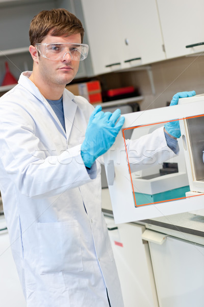 Stock photo: Assertive young scientist doing an experiment in his laboratory