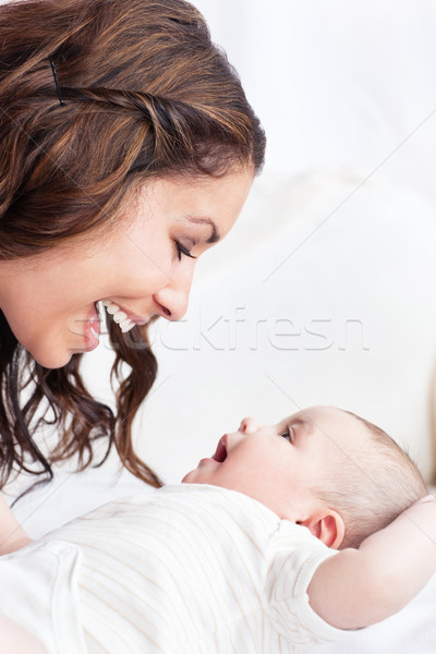 Portrait of an adorable mother playing with her baby sitting in the sofa at home Stock photo © wavebreak_media