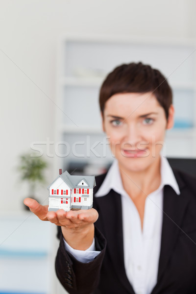 Portrait of a woman showing a miniature house with the camera focus on the object Stock photo © wavebreak_media