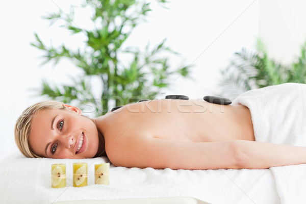 Stock photo: Blonde smiling woman having a stone therapy in a wellness center