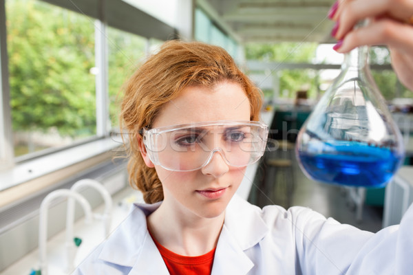 Science student looking at a flask with proctective glasses Stock photo © wavebreak_media