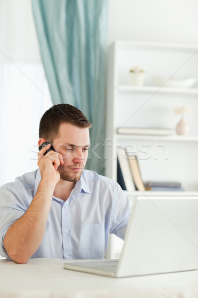 Young businessman with rolled up sleeves on the phone in his homeoffice Stock photo © wavebreak_media