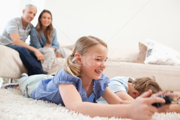 Children playing video games with their parents on the background in a living room Stock photo © wavebreak_media