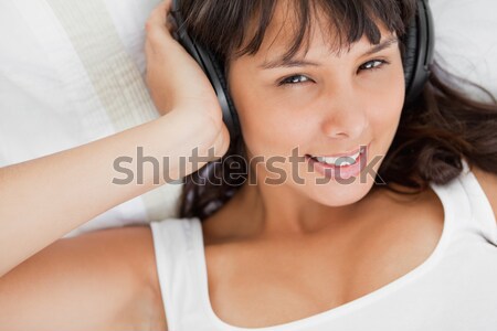 Portrait of a beautiful student in pajama while listening to music in her bed Stock photo © wavebreak_media