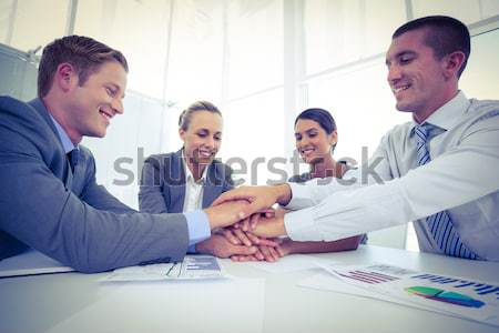 Stock photo: Young smiling executives shaking hands while looking at the camera