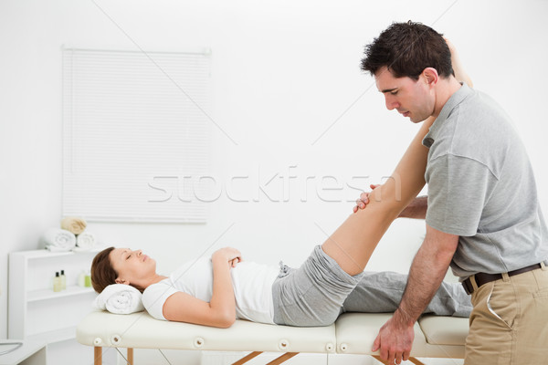 Man massaging a leg while placing it on his shoulder in a room Stock photo © wavebreak_media
