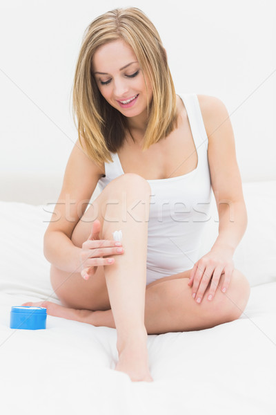 Kobieta krem nogi posiedzenia bed Zdjęcia stock © wavebreak_media