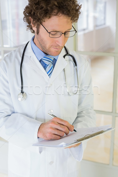 Grave doctor de sexo masculino escrito informes hospital guapo Foto stock © wavebreak_media