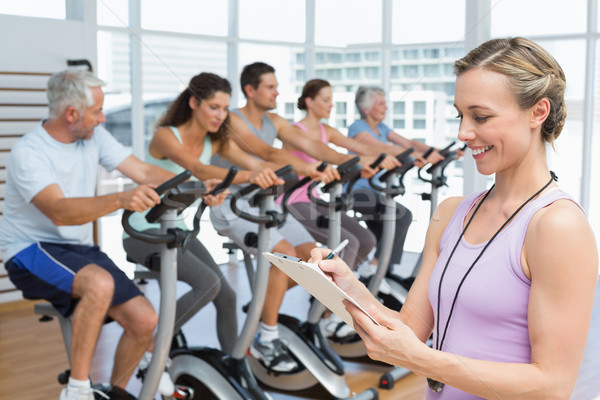 Trainer with people working out at spinning class Stock photo © wavebreak_media