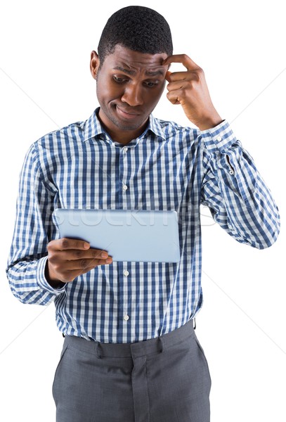 Young businessman thinking and holding tablet Stock photo © wavebreak_media