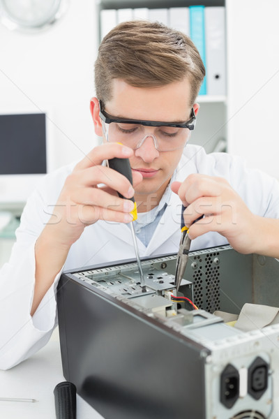 Stock photo: Computer engineer working on broken device with screwdriver
