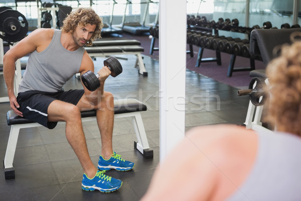 Young man exercising with dumbbell in gym Stock photo © wavebreak_media