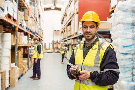 Smiling worker wearing yellow vest with arms crossed Stock photo © wavebreak_media