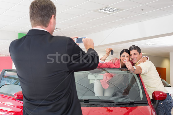 Businessman taking picture of the couple in their new car Stock photo © wavebreak_media