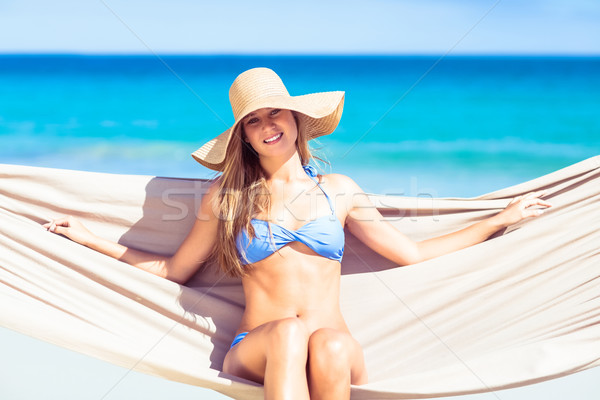 Stock photo: Pretty woman relaxing in the hammock and smiling at camera