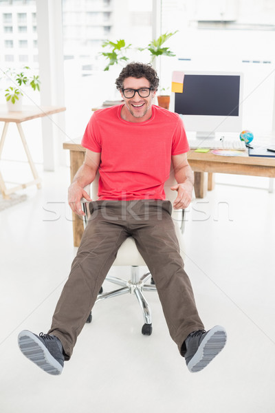  Handsome businessman sitting on a swivel chair and using his la Stock photo © wavebreak_media