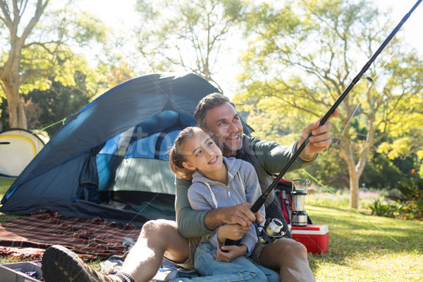 Father and daughter holding a fishing rod outside the tent Stock photo © wavebreak_media