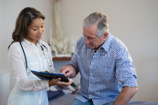 Senior male patient pointing at file while discussing with female therapist Stock photo © wavebreak_media