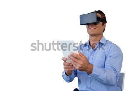 Smiling businessman with tablet sitting on chair while using vr glasses Stock photo © wavebreak_media