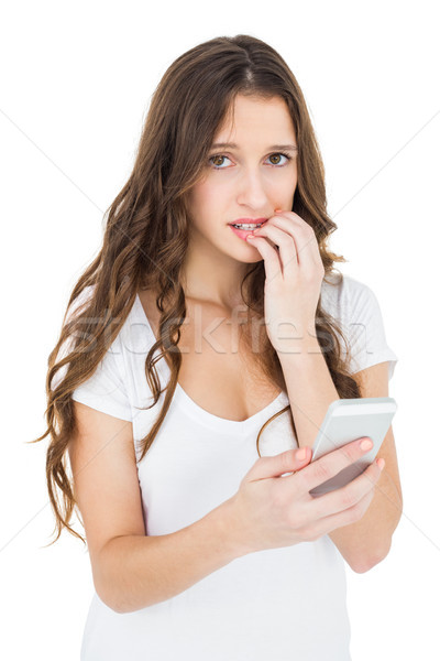 Stock photo: Worried woman using her smartphone