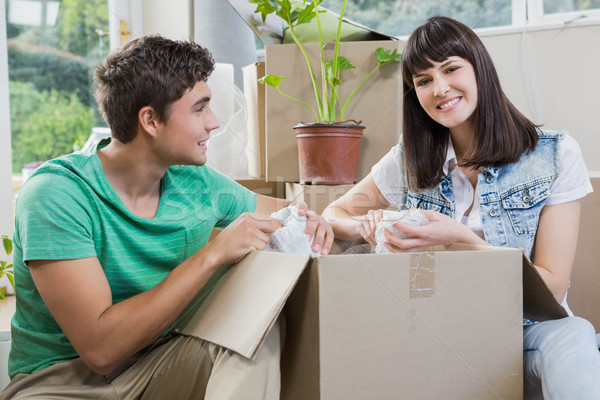 Stock photo: Young couple unpacking carton boxes in their new house