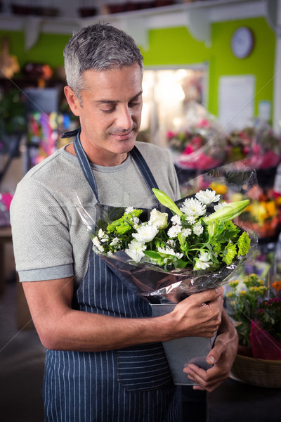 Stock photo: Male florist holding bunch of white flower in vase